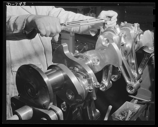 Assembling the rod and caps to an engine crankshank, using a tension wrench. Picture shows a crankshaft and connecting rod assembly. Packard marine engine plant, Detroit