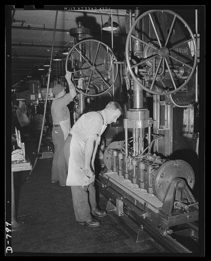 Machinists drilling and reaming valve guide holes in aluminum valve housings for the Packard marine engine. Packard marine engine plant, Detroit