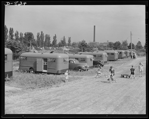 Defense housing, Erie, Pennsylvania. The spacious, open planning of the defense trailer camp affords youngsters pleant of room for playing in the sun and fresh air. In the background can be seen a smokestack of the General Electric Company, which employs some 10,000 men in defense work