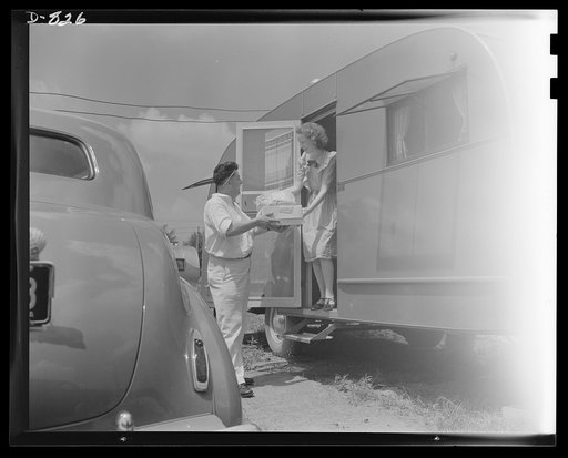 Defense housing, Erie, Pennsylvania. Mrs. B.J. Rogan receives deliveries of laundry, ice and grocery items from local businesses that serve the defense trailer camp twice daily. Mrs. Rogan's husband is employed by the General Electric Company as a drill press operator or defense work. Although groce
