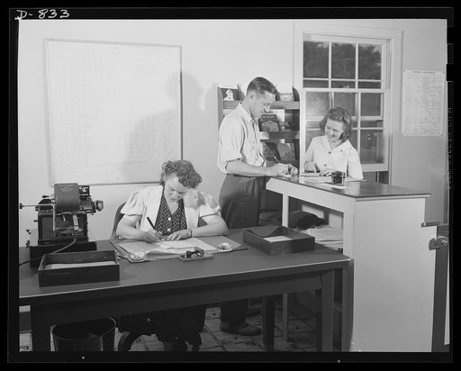 Defense housing, Erie, Pennsylvania. Milton Ackerman, manager of the Defense Trailer Project at Erie Pennsylvania, receives an application from Mrs. George Cole. Her husband is employed in the General Electric plant, which holds large defense contracts. Seated at the desk is Ackerman's assistant, wh