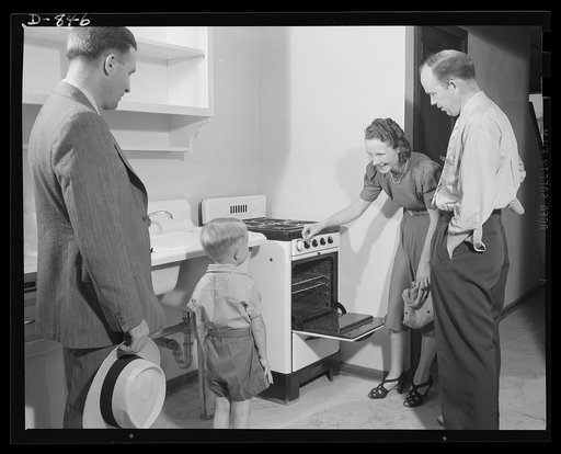 Defense housing, Erie, Pennsylvania. B.J. Rogan, General Electric Company, employee, and his family inspect the kitchen of their new defense home, while J.P. Kane, housing project manager, looks on. Each defense home is equipped with a gas operated refrigerator, gas range, and central heating plant.