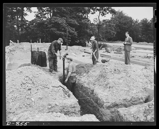 Defense housing, Erie, Pennsylvania. Plumbing is secured into position preparatory to filling in base with cinders. Most of the plumbing is pre-fabricated at a central shop on the construction site, then moved in one piece to the desired location