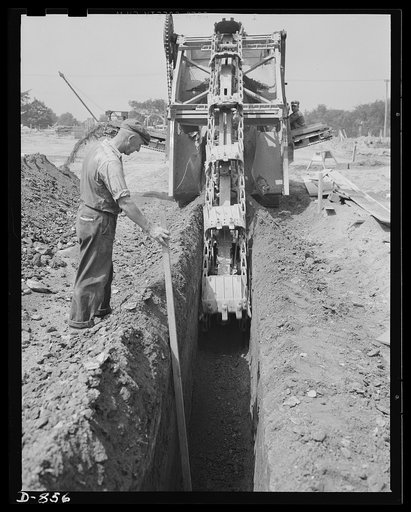 Defense housing, Erie, Pennsylvania. This excavator can dig foundation for two four-unit buildings in eight hours, an operation that would require several days by hand. Foundations go down five feet for cement support blocks. The ground between the foundation blocks is later forked preparatory to re
