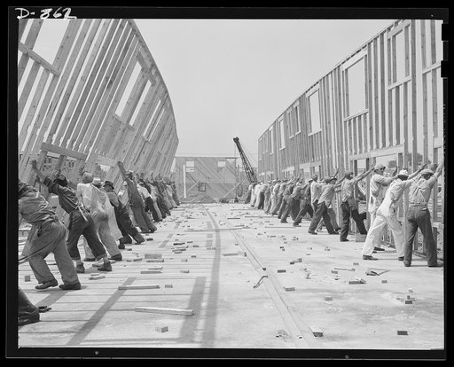 Defense housing, Erie, Pennsylvania. The entire framework, including sections for doors and windows, is fabricated horizontally. The crew working here will later move to another site and repeat the procedure. This circulation of crews who are experienced in one type of construction adds to the speed