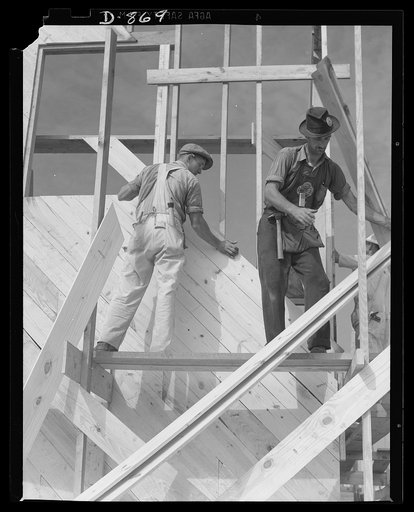 Defense housing, Erie, Pennsylvania. Fitting diagonal wall sheeting into place. The crew works on several sides of the unit at the same time. This work is so divided that there are just enough men at each spot to do the job efficiently