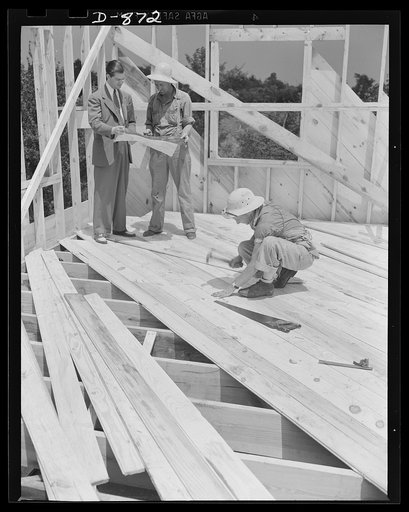 Defense housing, Erie, Pennsylvania. One part of the crew sheets the flooring as the walls are going up. The progress of the work is checked frequently against the working blueprints