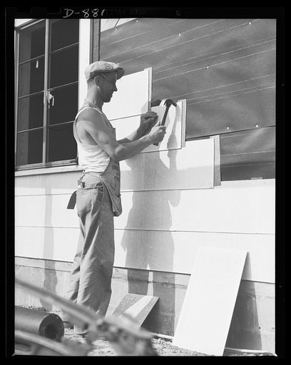 Defense housing, Erie, Pennsylvania. A shingling crew moves in. Exteriors are finished with an abestos cement composition shingle which provides insulation and weather-proofing. Shingles are secured over a tar-paper insulation with bronzed, rust resisting nails