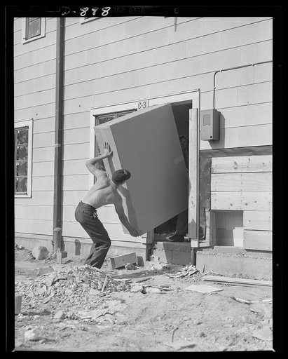 Defense housing, Erie, Pennsylvania. Modern bathrooms and kitchens are speedily installed in the 300 defense homes at the Franklin Terrace housing project. Here kitchen cabinets and shelving are carried in