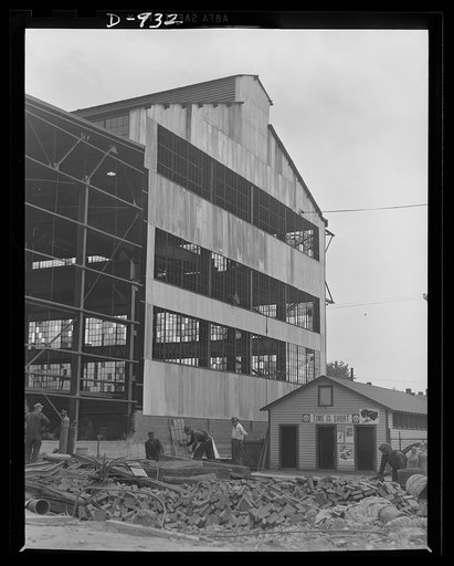 Posters in use. Office of Emergency Management (OEM) production posters displayed on the pay shack of the Allegheny Ludlum Steel Corporation in Brackenridge, Pennsylvania. The construction in the background is a new addition to the electric furnace building at the plant