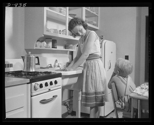 War housing. Mrs. B.J. Rogan and her small son, Bernie, in the kitchen of the Rogan's new war home at the Franklin Terrace housing project in Erie, Pennsylvania. Mr. Rogan is a drill press operatorat a nearby plant which is working three shifts on war contracts. The Rogans pay about twenty percent o