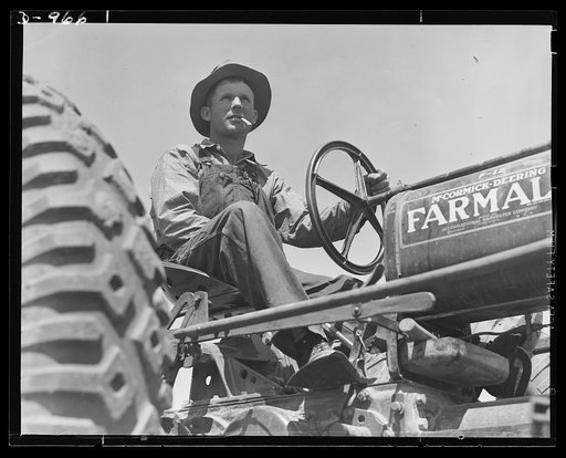 Productive America. A Texas farmer takes time out for a smoke and a proud look over his rich productive acres. The extensive flat farming lands permit full use of mechanized equipment