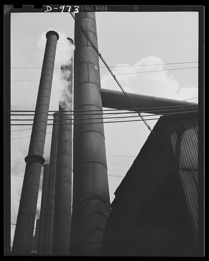Steel alloy manufacture. Allegheny Ludlum Steel Corporation, Brackenridge, Pennsylvania. Power for the wheels of defense industry. The stacks of the power house which generates all the steam required in this plant. The heavy wires in the foreground carry current to the electric furnaces used to conv