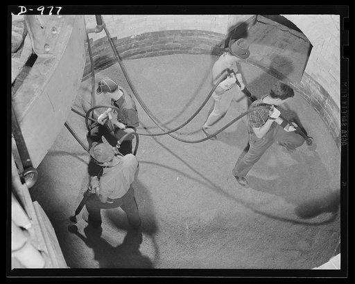 Steel alloy manufacture. America builds for its Arsenals of Democracy. Workers ramming in the bottom of a new thirty-five ton electric melting furnace which two days later was placed in operation to produce steel alloys from scrap iron and steel. This plant is being expanded at record speed to keep 