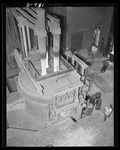 Steel alloy manufacture. Allegheny Ludlum Steel Corporation, Brackenridge, Pennsylvania. Thirty-five ton electric arc melting furnace in operation. These furnaces convert scrap iron and steel into high quality steel alloys. This type of furnace gives much faster heating and permits the accurate temp