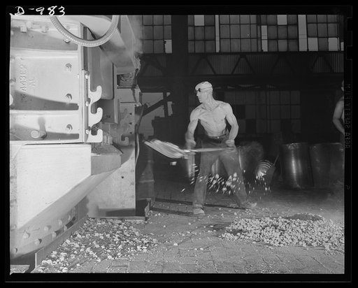 Steel alloy manufacture. Allegheny Ludlum Steel Corporation, Brackenridge, Pennsylvania. Converting scrap iron and steel into high quality alloy steel. A workman adds alloying materials to the bath of molten steel in one of the thirty-five ton electric arc furnaces. These furnaces give faster heatin