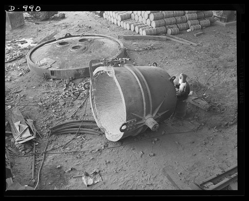 Steel alloy manufacture. Allegheny Ludlum Steel Corporation, Brackenridge, Pennsylvania. Giant at rest. A repairman mends one of the huge ladles in which molten steel is conveyed from the electric furnaces to the ingot moulds