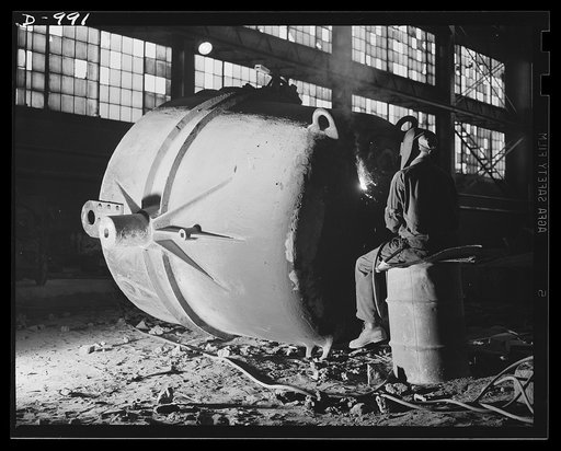 Steel alloy manufacture. Allegheny Ludlum Steel Corporation, Brackenridge, Pennsylvania. Giant at rest. A repairman mends one of the huge ladles in which molten steel is conveyed from the electric furnaces to the ingot moulds