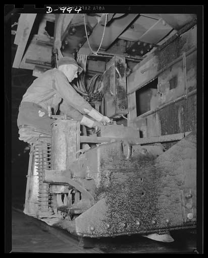 Steel alloy manufacture. Allegheny Ludlum Steel Corporation, Brackenridge, Pennsylvania. Open hearth steel is also made at this plant. Here a worker sits at the controls of the charging mechanism for loading materials and elements into the furnace. This open hearth furnace has a capacity of about 10