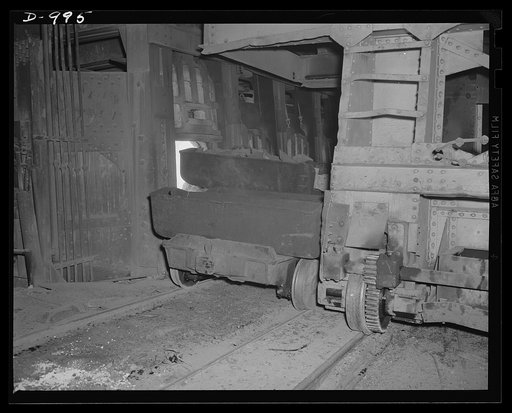 Steel alloy manufacture. Allegheny Ludlum Steel Corporation, Brackenridge, Pennsylvania. Open hearth steel is also made at this plant. Raw materials are charged into an open hearth furnace by means of this charging mechanism. The open hearth furnaces have a capacity of about 100 tons of steel per he