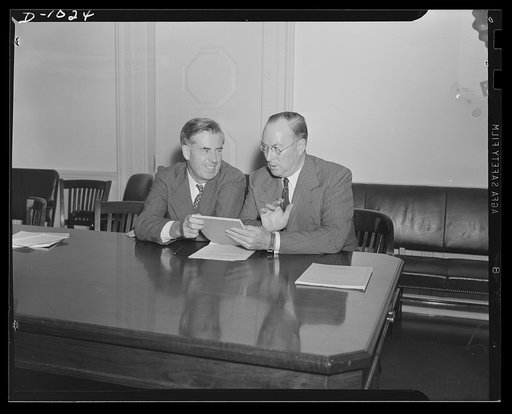 Henry A. Wallace, Chairman, Supply Priorities and Allocations Board and Vice-President of the United States, and Donald M. Nelson, Executive Director, Supply Priorities and Allocations Board and Director of the Priorities Division, Office of Production Management (OPM). Photograph taken at a joint p
