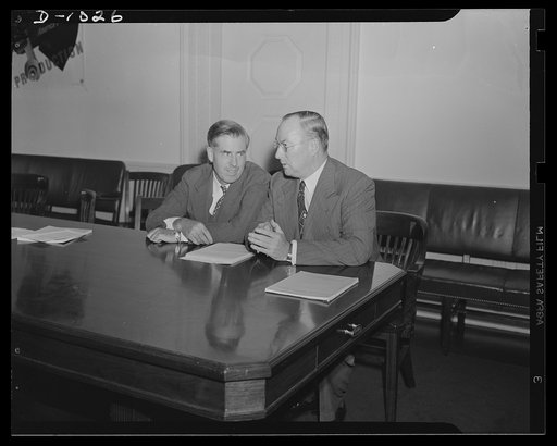 Henry A. Wallace, Chairman, Supply Priorities and Allocations Board and Vice-President of the United States, and Donald M. Nelson, Executive Director, Supply Priorities and Allocations Board and Director of the Priorities Division, Office of Production Management (OPM). Photograph taken at a joint p
