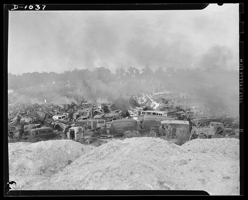 Conservation. Scrap iron and steel. Firing scrapped automobiles to provide steel for the National Defense production program. In these auto graveyards scrapped cars are stripped of all usable parts and then sent to scrap iron dealers who press and bale the metal for shipment to steel mills