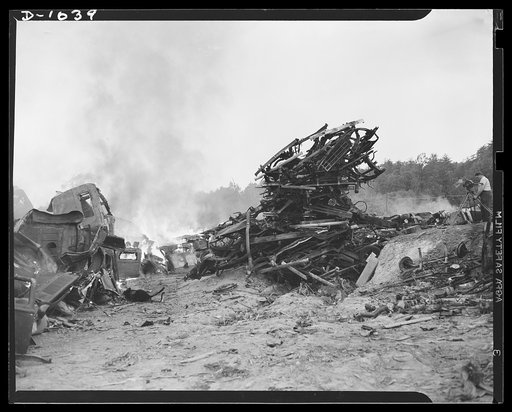 Conservation. Scrap iron and steel. Firing scrapped automobiles to provide steel for the National Defense production program. In these auto graveyards scrapped cars are stripped of all usable parts and then sent to scrap iron dealers who press and bale the metal for shipment to steel mills