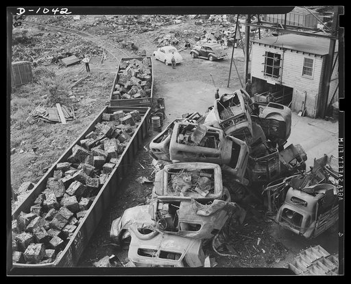 Conservation. Scrap iron and steel. Steel for national defense. Scrap iron to feed the hungry furnaces of the steel mills (at least fifty percent scrap must be used in the open hearth process). In this Baltimore scrap iron dealer's plant, car bodies are compressed hydraulically into small cubes