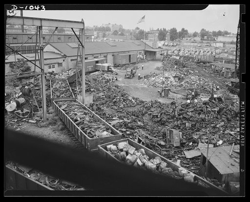 Conservation. Scrap iron and steel. Steel for national defense. Scrap iron to feed the hungry furnaces of the steel mills (at least fifty percent scrap must be used in the open hearth process). In this Baltimore scrap iron dealer's plant, car bodies are compressed hydraulically into small cubes