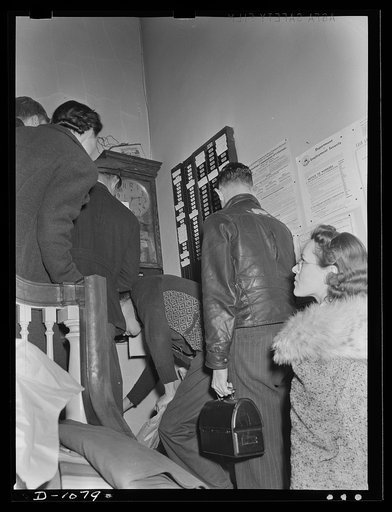 Army tent manufacture.  Schaeffer Tent and Awning Company, Denver, Colorado. Workers checking in for the second shift on the production of eight-man pyramidial tents to house the expanding defense army in the field.