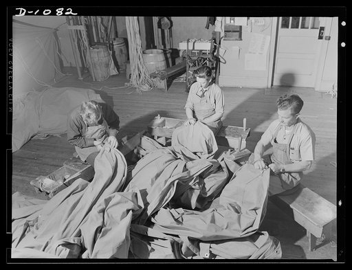 Army tent manufacture.  Schaeffer Tent and Awning Company, Denver, Colorado. Manufacture of eight-man pyramidal tents to house the expanding defense Army in the field. These workers are on hand sewing rings and webbs on a few of the ninety-five tents produced in this small plant each day. Army Quart