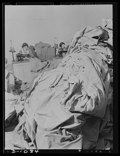 Army tent manufacture.  Schaeffer Tent and Awning Company, Denver, Colorado. Some of the ninety-five eight-man pyramidal tents being manufactured per day by this small plant. In the background workers are sewing the sod cloths for these tents. Each tent is made to rigid Army Quartermaster Corps spec