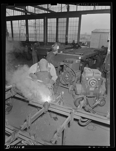 Trailers for defense transportation. Winter Weiss Company, Denver, Colorado. Manufacture of semi-trailers for general utility use in Army camps. The trailers are equipped with combination platform and stake bodies. Trailer frames are here being electrically welded on high tensile steel jigs