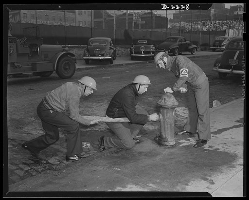 The air raid protective services. One of the things an auxiliary fireman must learn is that the hose must be free of kinks before the water is turned on. Proper laying of fire hose is a technique of itself, a technique in which the volunteers must be instructed