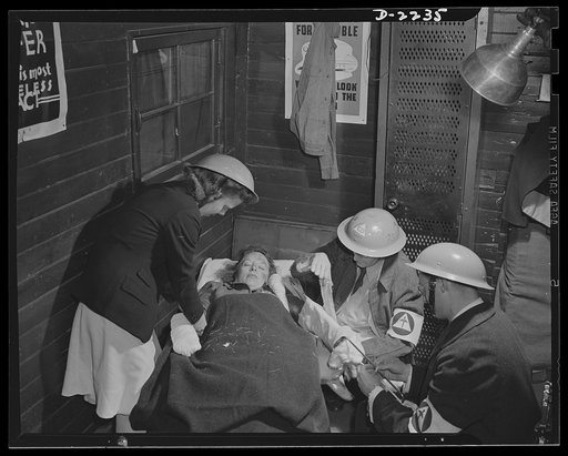 The air raid protective services. Members of the emergency medical corps are trained to treat all casualties with the greatest possible speed. Here two workers apply splint, while a third completes a dressing. From this emergency station, the victim will be sent by ambulance to a hospital