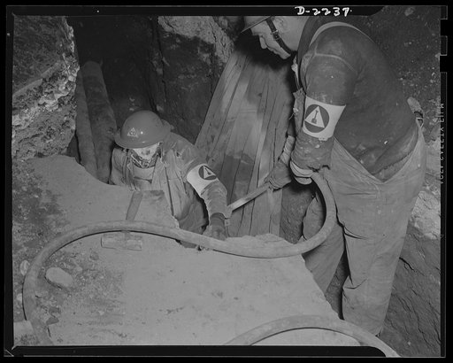 The air raid protective services. Civilian protection workers go after damaged lines to restore service immediately. Insignia is that of road repair squads, but rescue squad and utility repair squad members may do similar work