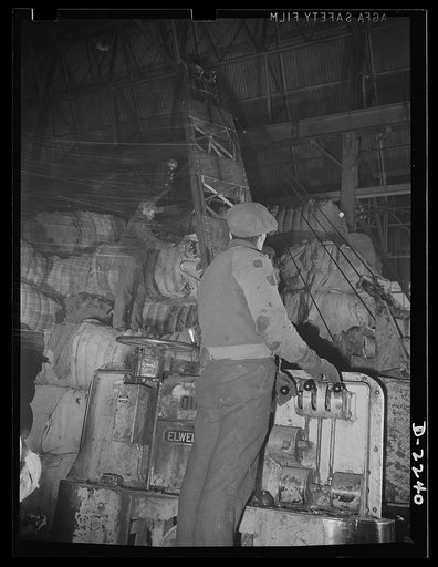 Rags. Collection and processing. Scene in the storeroom of a large Eastern rag processing plant. An electric crane lifts the bales and places them in piles, where they await sorting. Shapiro Company, Maryland