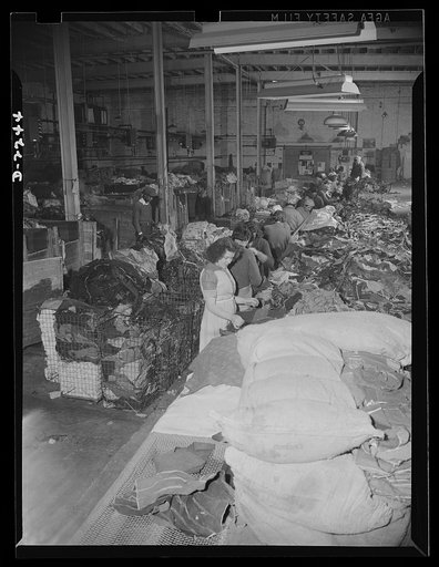 Rags. Collection and processing. A portion of the sorting room in a large Eastern rag processing plant. In this room new rag remnants, consisting chiefly of cuttings received from clothing factories, are sorted. The rags are classified and separated according to the type of cloth; colored rags are g