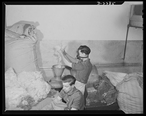 Bantam, Connecticut. While Patsy DiGiovanni puts kapok through the filler machine, which fluffs it out, Chet Wash is stuffing the back cushion of bomber pilot's seat in the upholstery shop of the Warren McArthur Corporation. Patsy came to work here in April 1941, from his native Torrington, where he
