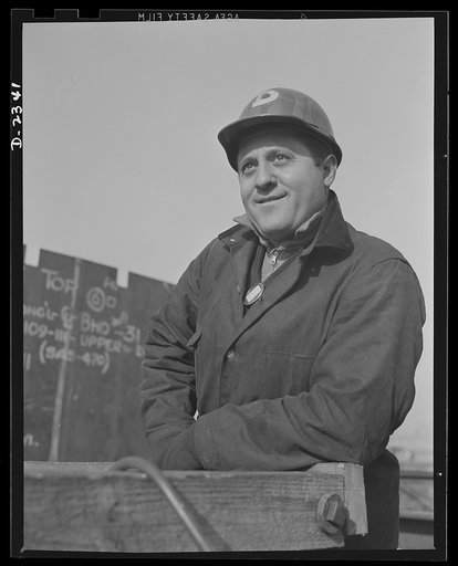 Shipbuilding. "Liberty" ships. This is the signal man of a riggers crew at a large Eastern shipyard. He is about ready to give the go-ahead signal to the operator of a large overhead electric crane. Bethlehem-Fairfield Shipyards Inc., Baltimore, Maryland