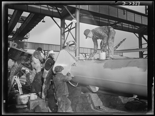 Shipbuilding. "Liberty" ships. Nearly ready to be hoisted into place on the deck of a new ship under construction at a large Eastern yard, this mast is given its final coat of paint