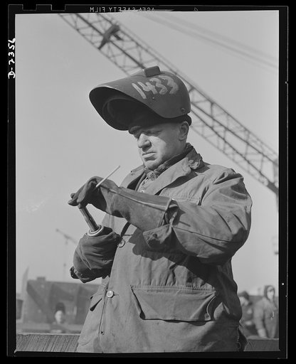 Shipbuilding. "Liberty" ships. Electric welding is a vital skill in the building of Uncle Sam's new merchant fleet. This welder inserting a new rod in his charged holder, on one of the ships. Production scene in an Eastern shipyard. Bethlehem-Fairfield Shipyards Inc., Baltimore, Maryland