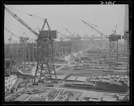 Shipbuilding. "Liberty" ships. This maze of rolling cranes, at a large Eastern shipyard is a typical scene in many large shipyards at work on ships for Uncle Sam's Navy and merchant fleet. Stocks of material are piled up for the cranes to take to vessels under construction so there is no delay in pr