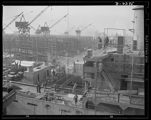 Shipbuilding. "Liberty" ships. This is the midship section of a new member of the Liberty Fleet, nearing completion at a large shipyard. In the background is a maze of scaffolding and cranes typical of the scene in many large American shipyards as builders work to make Uncle Sam master of the seas