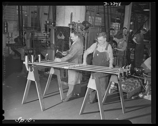 Conversion. Merry-go-round plant. The stamp of approval goes on these sections of naval shell extractors before they are shipped from this New York state plant doing war work on subcontract. The plant formerly turned out merry-go-rounds. The naval inspector is at the left. Spillman Engineering Compa