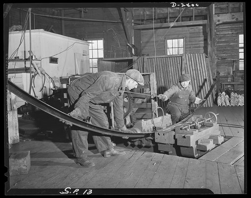 Conversion. Merry-go-round plant. In times of peace, this horizontal bulldozer was used to fashion parts for merry-go-rounds to lighten the hearts of carefree children. The drill press has now been converted so that it can perform a face milling operation on landing gear cases for Airacobras. Mathew