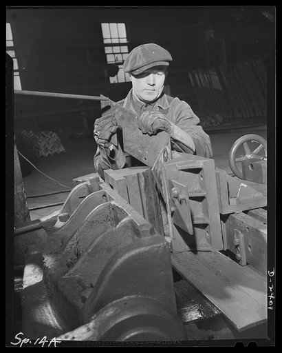 Conversion. Merry-go-round plant. Hooks for export packing cases of aircraft engines are bent on this horizontal bulldozer which was formerly used to bend rails for merry-go-rounds to delight the hearts of carefree children. It was thought impossible to convert the machine for this use, but a little