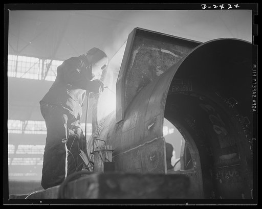 Shipbuilding. "Liberty" ships. Welding is more important than ever before in shipbuilding, saving time, weight and steel. This welder is working on the foundation for steel pillars to support the decks on top of the shaft tunnel of a new merchant ship under construction at a large Eastern plant. All