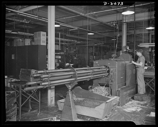 A New Britain-Gridley lathe is worked by an experienced operator at a Midwestern company. The machine which formerly made spur gears, worm wheels and commentator rings has been converted to war use by being tooled with an eccentric spindle and thread rolling attachment for the production of twenty-m